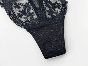 Close-up of black floral lace and breathable polka dot mesh fabric detail