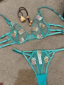 Detail of teal lace lingerie set with pineapple embroidery and sheer mesh texture
