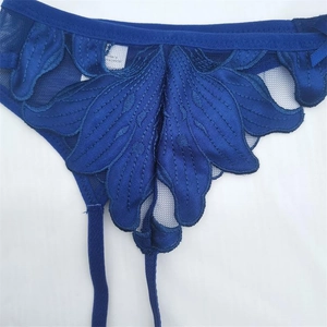 Gros plan sur le porte-jarretelles en dentelle bleu foncé avec broderie de feuilles fines
