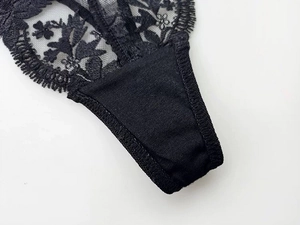 Detail view of the black lace embroidery and stitched crotch area of women's sexy thong