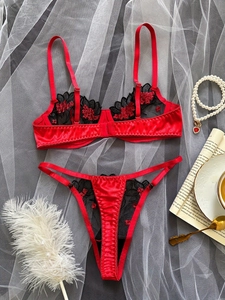Close-up of red lingerie set with black lace and 3D floral embroidery details