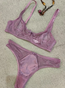 Flat lay of purple lace lingerie set featuring floral embroidery and mesh details