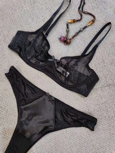 Detailed flat lay of a black lace lingerie set with mesh bra and sleek thong design