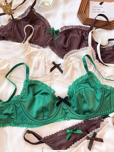 Flat lay of lace satin bras in green, cream and coffee colors with floral embroidery