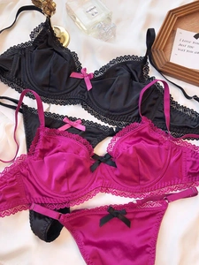 Flat lay of satin and heart lace lingerie sets in black and rose red colors
