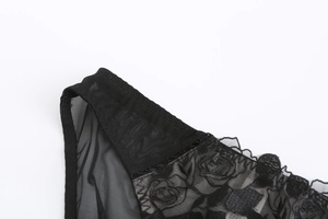 Detail shot of black lace bra featuring 3D rose flower embroidery and sheer mesh