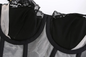 Detail of lace stitching and corset-style mesh support on the satin lingerie set