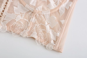 Détails de broderie florale sur corset en tulle transparent avec baleines de soutien
