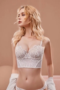 Détail d'un corset en dentelle florale blanche avec tulle et anneau métallique décoratif