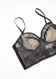 Close-up of black lace bra detail with delicate wave patterns and adjustable straps