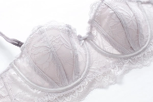 Detail of floral lace bra with delicate eyelash edges and center bow in lilac