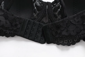 Detail of black lace bra featuring four-row hook-and-eye back closure and fine floral mesh