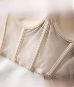 Detailed macro view of beige mesh fabric and supportive flexible boning for shaping