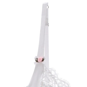 Close-up of white satin bra with delicate lace trim, pink rose, and bow detail