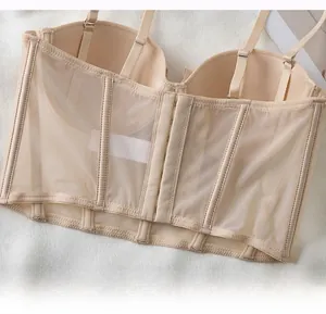 Detail of beige lace corset bra featuring reinforced side wings and multi-hook closure
