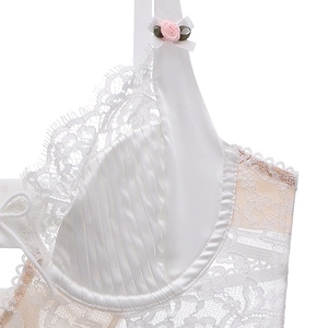 Close-up of white eyelash lace bra with satin pleats and a delicate pink rose detail