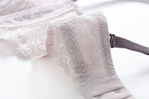 Detail of delicate pink eyelash lace fabric and metal hook closure for strapless bra