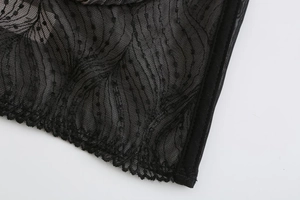 Detail of French lace embroidery with scalloped edges and black mesh polka dot pattern
