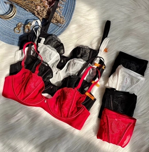 Flat lay of lace embroidery lingerie sets in red, black and white on plush carpet