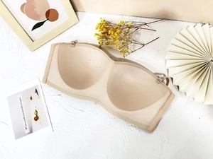 Seamless strapless push-up bra in beige displayed with artistic props on white background
