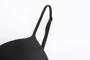 Detail of adjustable thin shoulder straps and seamless smooth cups on black bra