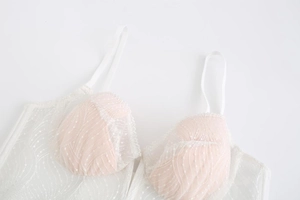 Close-up of white French embroidery lace lingerie with delicate mesh and thin straps