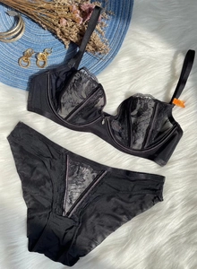 Close-up of black floral embroidery on sheer mesh lace bra and panty set for women