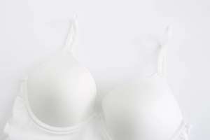 Close-up of white seamless bra with adjustable straps and fine fabric texture details