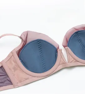 Detail of thin cup lining with blue fabric and pink mesh stitching on French style bra
