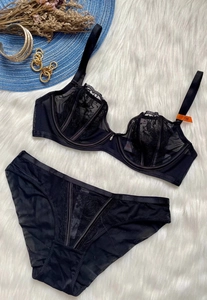 Detail of black French lace lingerie set with mesh embroidery and size 75B tag