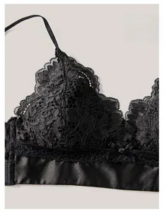 Dettaglio ravvicinato del reggiseno in pizzo nero con motivi floreali e fiocco in raso
