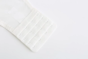 Close-up of white 4-row bra extender hooks with high-quality stitching detail