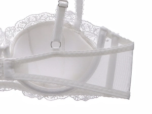 Close-up of white floral lace embroidery and adjustable silver buckle on bra strap