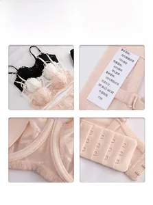 Detail view of lace mesh bra with bow embroidery, washing label, and back closure hooks