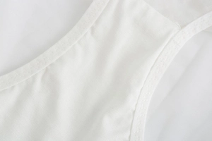 Détail de la dentelle brodée et des coutures précises sur un soutien-gorge en coton