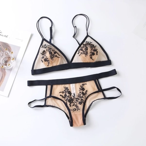 Ensemble de lingerie brodé de fleurs noires sur tulle, disposé à plat sur fond blanc