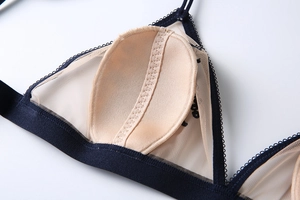 Détail d'un soutien-gorge en résille marine avec coussinets amovibles et coutures festonnées