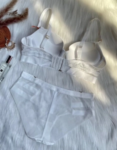 Dettaglio in piano di set lingerie bianca senza cuciture su tappeto morbido con decori