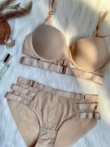 Set lingerie nude senza cuciture con spalline regolabili su sfondo di peluche bianco