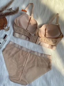 Dettaglio flat lay di un set reggiseno nude senza cuciture con slip in pizzo satin