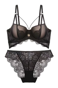 Detail eines schwarzen Spitzen-Dessous-Sets mit floralem Netz und goldenem Verschluss