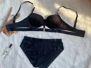 Dettaglio flat lay di un set lingerie nero senza cuciture con fibbie dorate, 75B