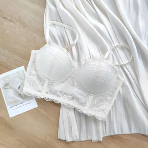Détail d'un soutien-gorge en dentelle blanche avec motifs floraux et festonnés