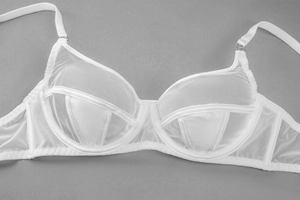 Close-up detail of white sheer mesh bra with supportive underwire and adjustable straps