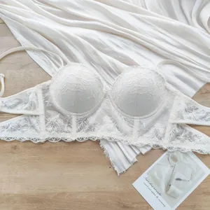 Détail du soutien-gorge corset en dentelle blanche avec motifs floraux et baleines