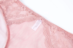 Detail view of pink lace underwear showing 100% cotton crotch lining and laundry label