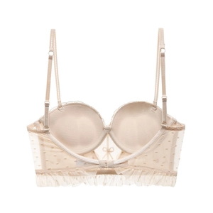Detail of beige lace bra with adjustable straps, bow accent, and ruffled hem finish