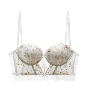 Close-up of white lace embroidery bustier with gold floral patterns and scalloped edges