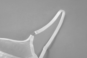 Detail of white mesh lace bra cup showing elastic strap and silver metal ring buckle