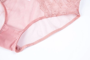Detailed close-up of pink lace and sheer mesh fabric on women's elegant underwear